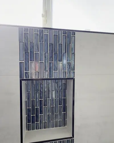 Shower niche framed in blue glass tile