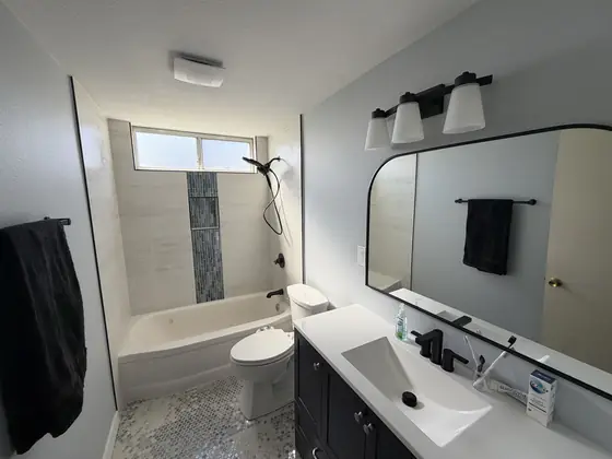The finished room: navy vanity, hex marble floor, blue glass accent