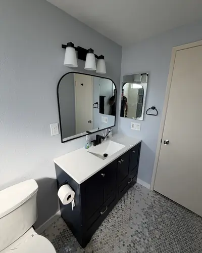 Shaker vanity with an arched black mirror